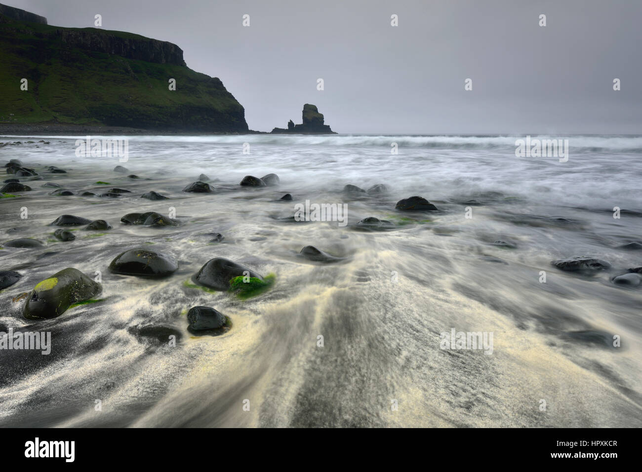 Les pierres dans le sable sur la plage de Talisker Bay, falaises et rochers, Ile de Skye, Ecosse, Royaume-Uni Banque D'Images