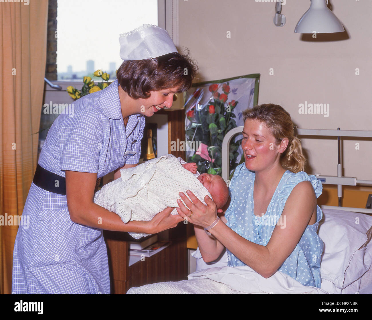 Midwive avec mère et bébé dans une salle de maternité (1990), City of Westminster, London, Greater London, Angleterre, Royaume-Uni Banque D'Images