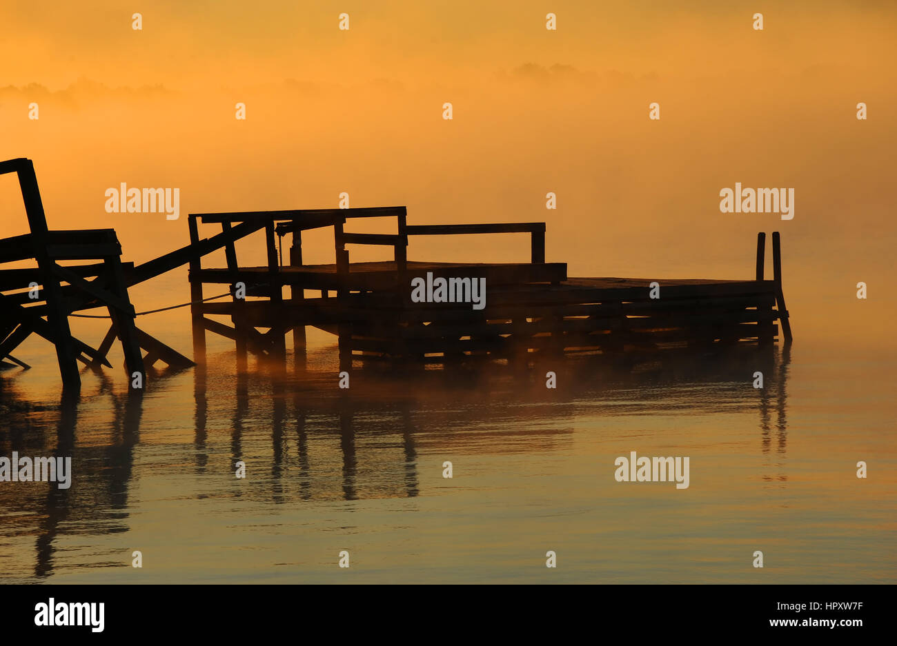 Pier en décomposition est entouré par la lumière dorée de l'aube sur le lac Chicot à Lake Village, Arkansas. Banque D'Images