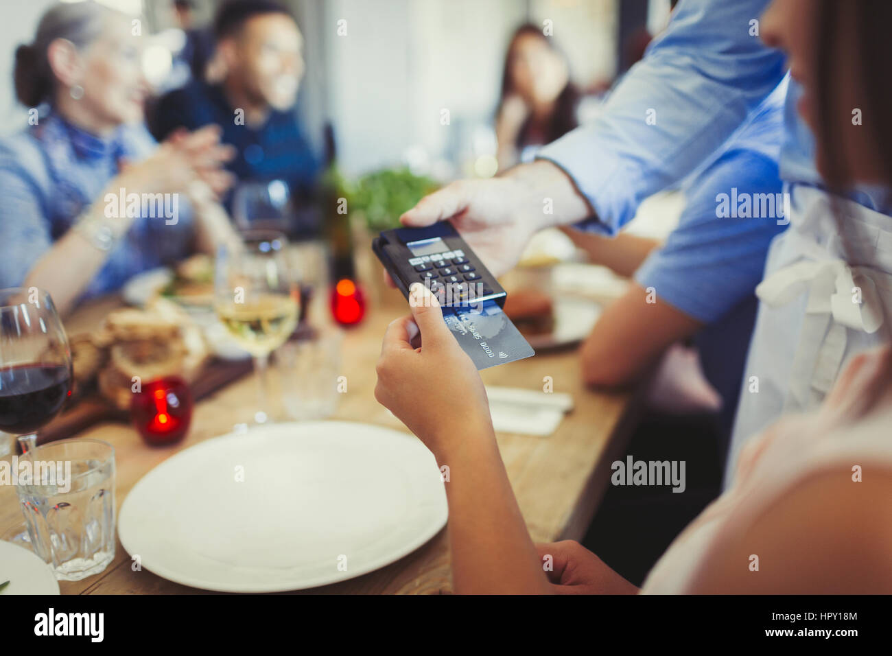 Femme avec carte de crédit Paiement par carte de crédit, chef de lecteur à table restaurant Banque D'Images