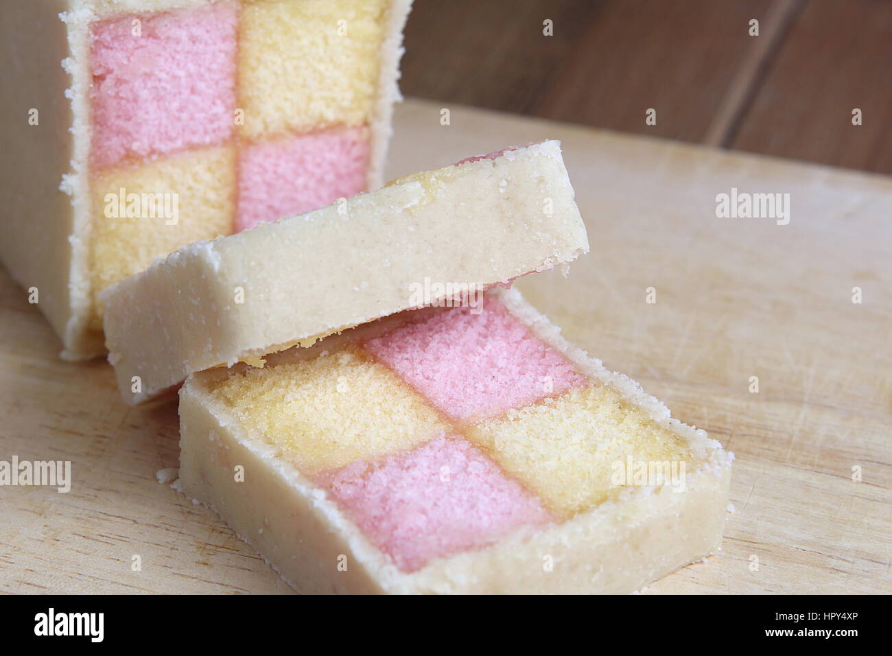 Battenberg fraîchement coupées avec gâteau éponge rose et jaune, recouvert de massepain Banque D'Images
