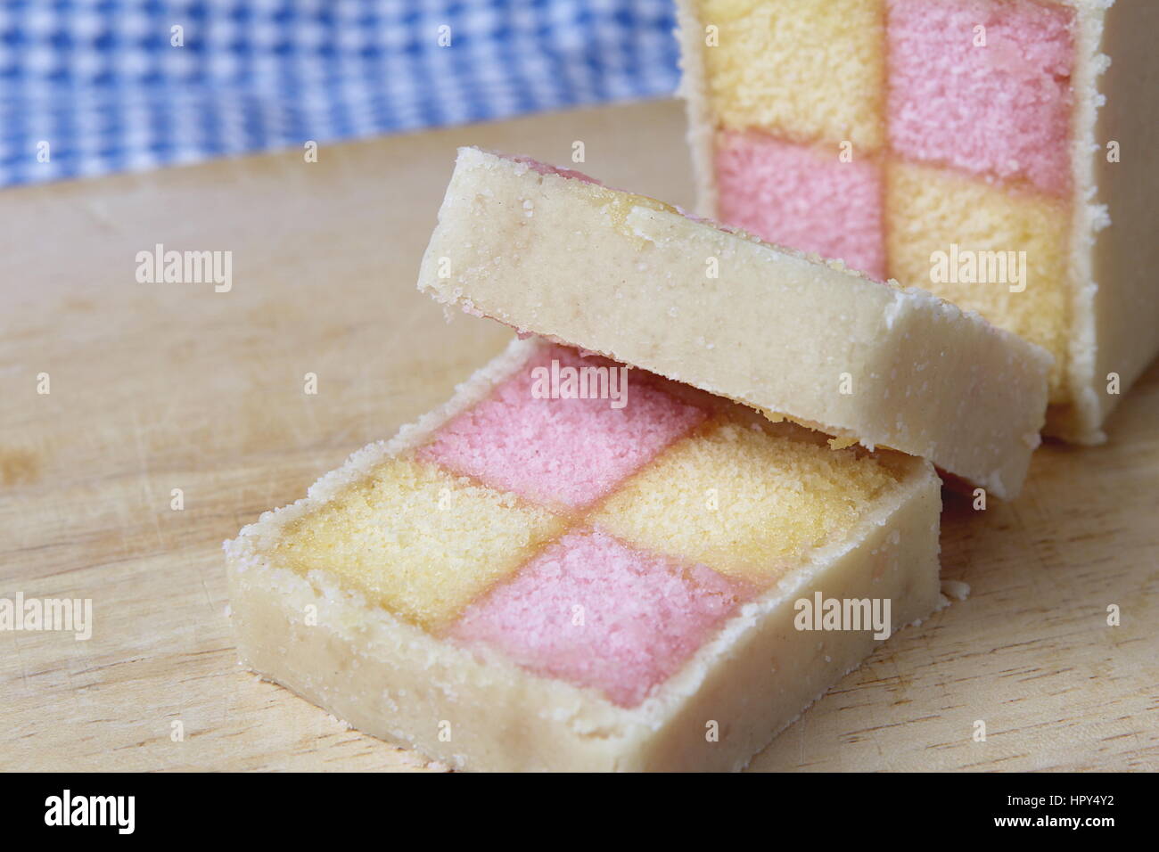 Battenberg fraîchement coupées avec gâteau éponge rose et jaune, recouvert de massepain Banque D'Images