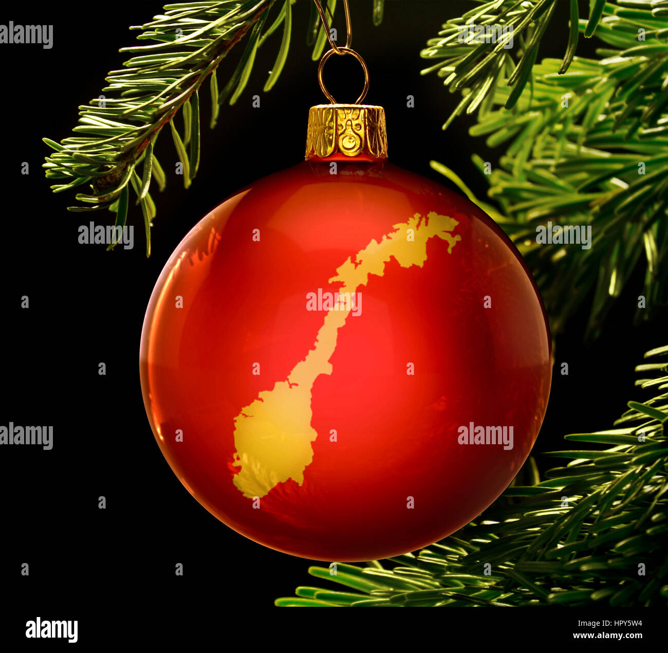 Une babiole rouge avec la forme d'or de la Norvège accroché sur un arbre de Noël isolé sur noir.(série) Banque D'Images