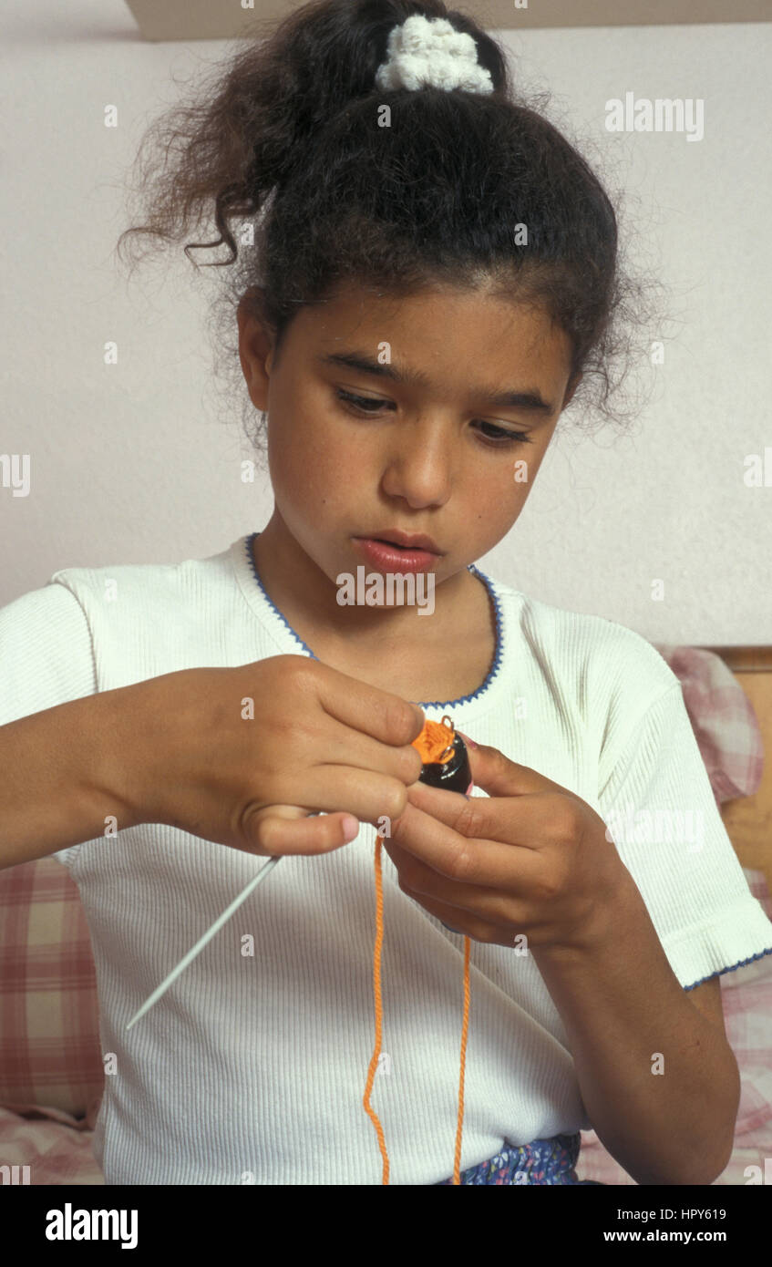 Jeune fille multiculturelle faisant tricotin Banque D'Images