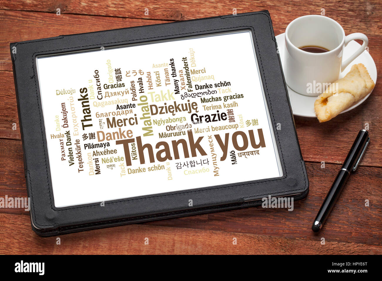 Merci en différentes langues - Nuage de mots sur une tablette numérique avec une tasse de café contre bois grunge Banque D'Images
