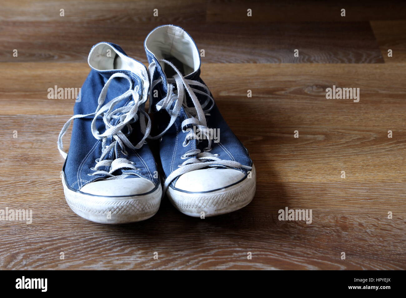 Paire de baskets bleu et blanc bottes formateurs sur fond de bois avec un espace réservé au texte Banque D'Images