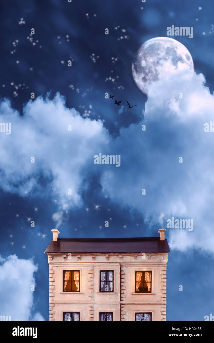 Maison de poupées modèle contre un ciel de nuit avec la lune et les étoiles Banque D'Images