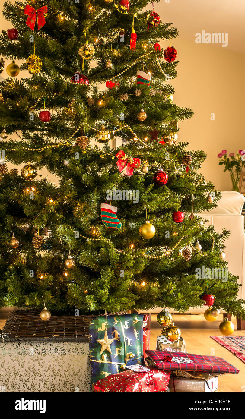 Sapin de Noël décoré de cadeaux sous l'arbre dans un salon à l'intérieur de la maison, Écosse, Royaume-Uni Banque D'Images
