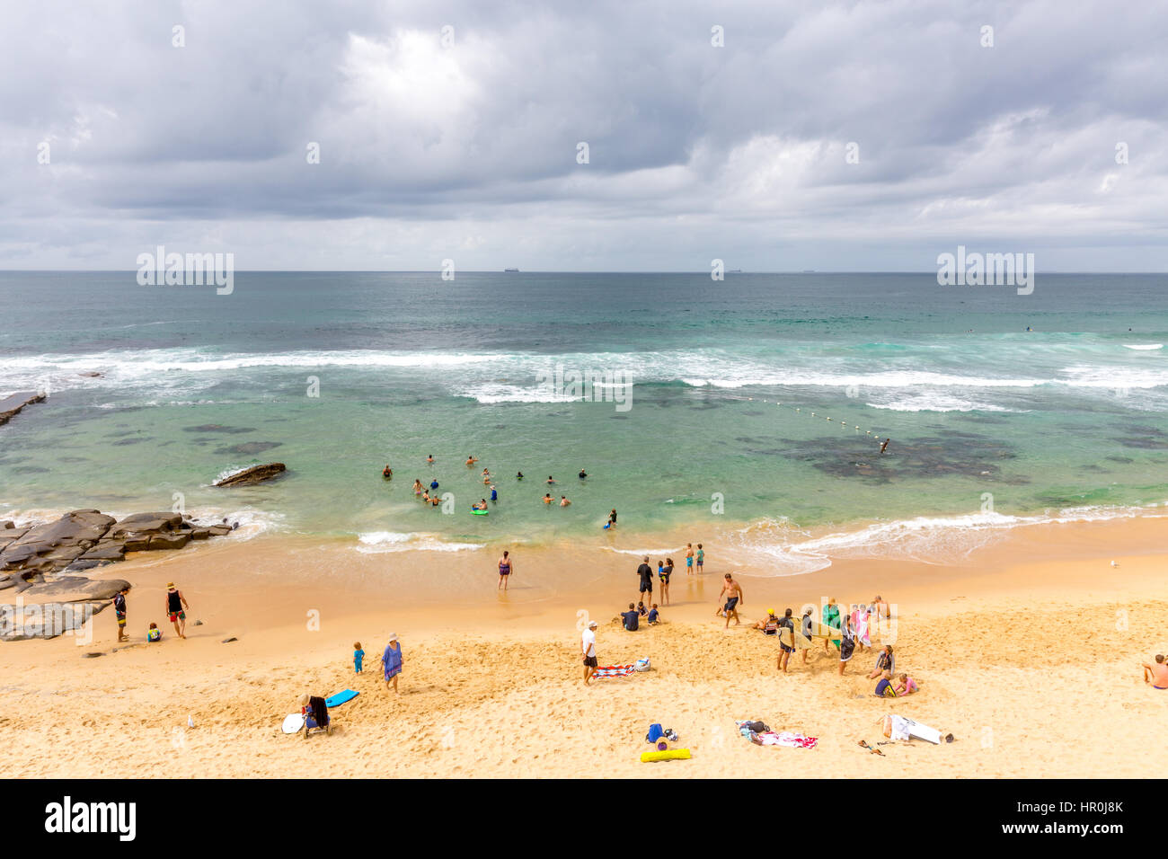 Plage de bar à Newcastle en Nouvelle Galles du sud,avec transporteur de vrac conteneurs navires attendant d'entrer dans le port, de l'Australie Banque D'Images