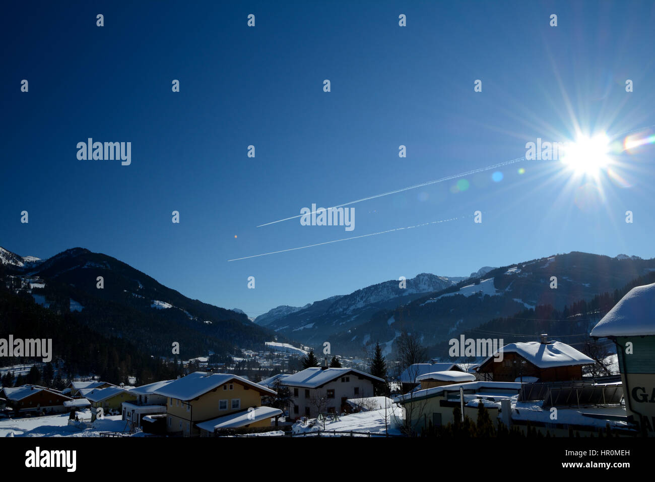 Wagrain, Autriche - 28 janvier 2017 : Immeubles, montagnes, ciel et soleil en Wagrain dans les Alpes en Autriche. Banque D'Images