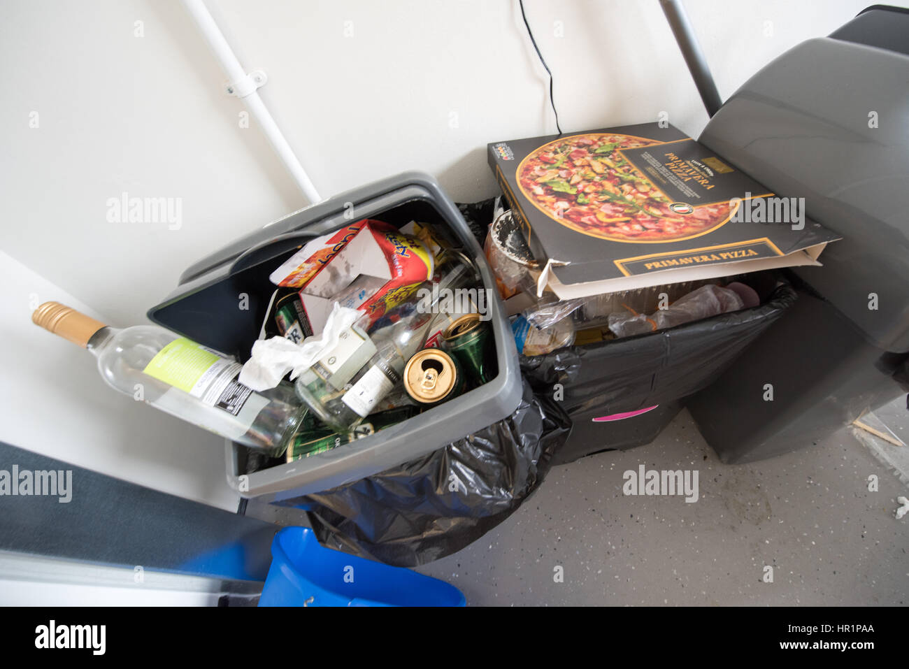 Cuisine sale débordante de swing en plastique bacs pleins d'ordures, boîtes à pizza, des bouteilles de vin, des canettes de bière et une résidence étudiante cuisine commune Banque D'Images