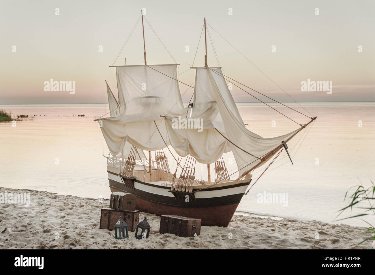 Bateau en bois avec des voiles blanches d'un séjour sur la plage Banque D'Images