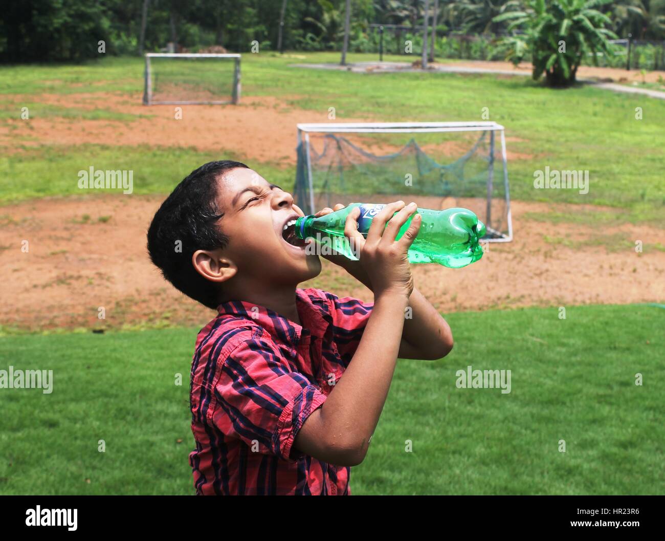 Thirsty boy drinking water Banque D'Images