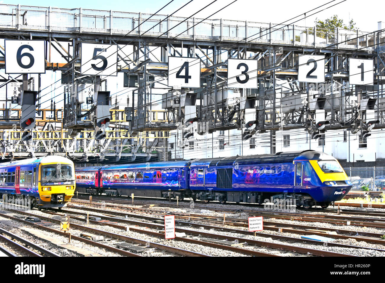 Deux Firstgroup First Great Western uk train a quitté la gare de Paddington à Londres en passant par le dessous du bras de signal importante nombre surdimensionné Banque D'Images