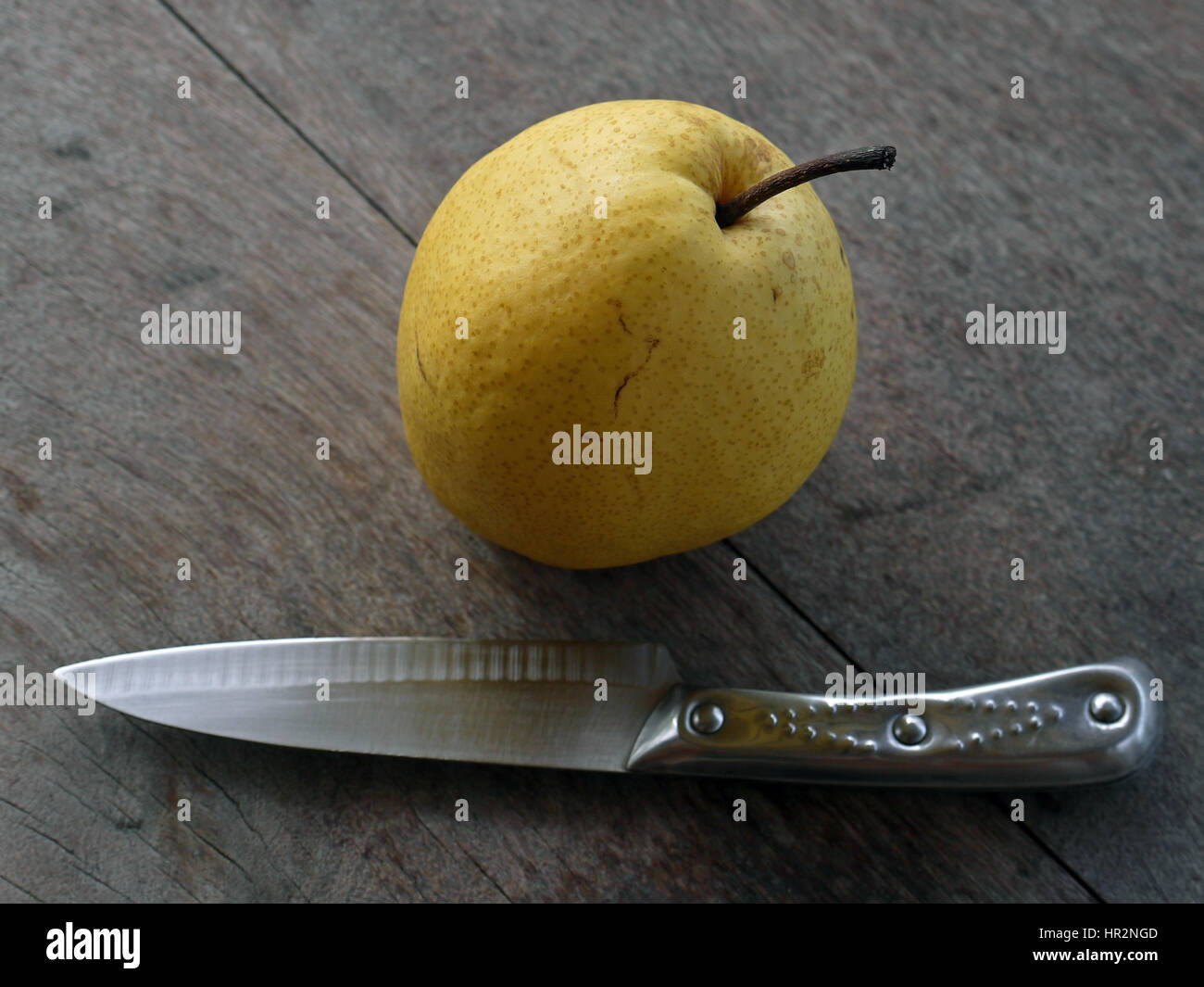 De forme de pomme poire sur une table en bois, avec un couteau Banque D'Images