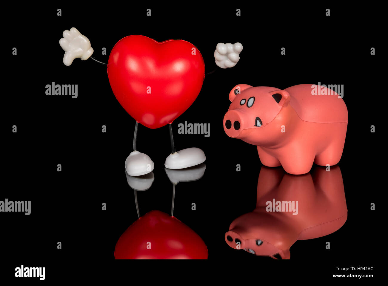 Cochon rose et un cœur rouge qui sont à la fois des jouets Banque D'Images