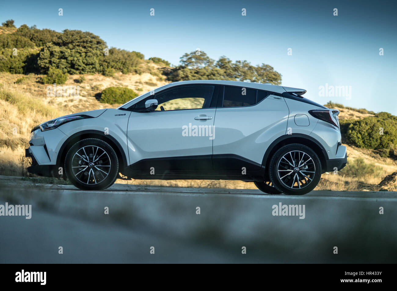 Sur le côté d'une Toyota blanche C-HR CHR sur un héliport, les collines et le paysage en arrière-plan. Banque D'Images