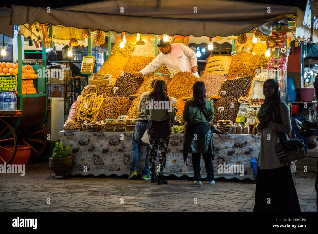 Marrakech, Maroc. Vendeur de noix et fruits séchés dans le Souk de nuit. Banque D'Images