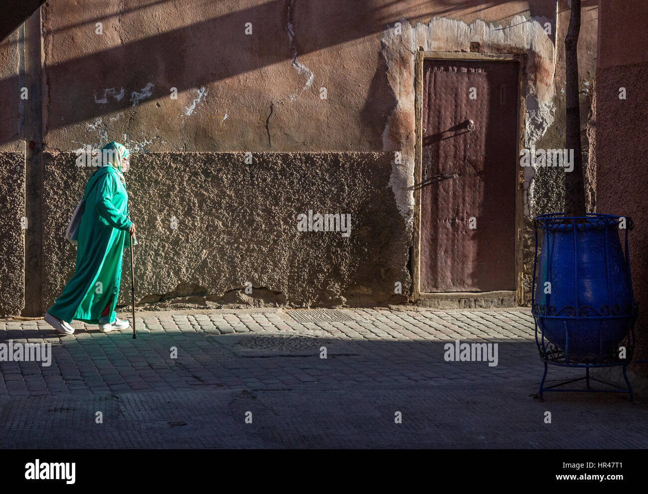 Marrakech, Maroc. Femme marche dans la Médina, au petit matin. Banque D'Images