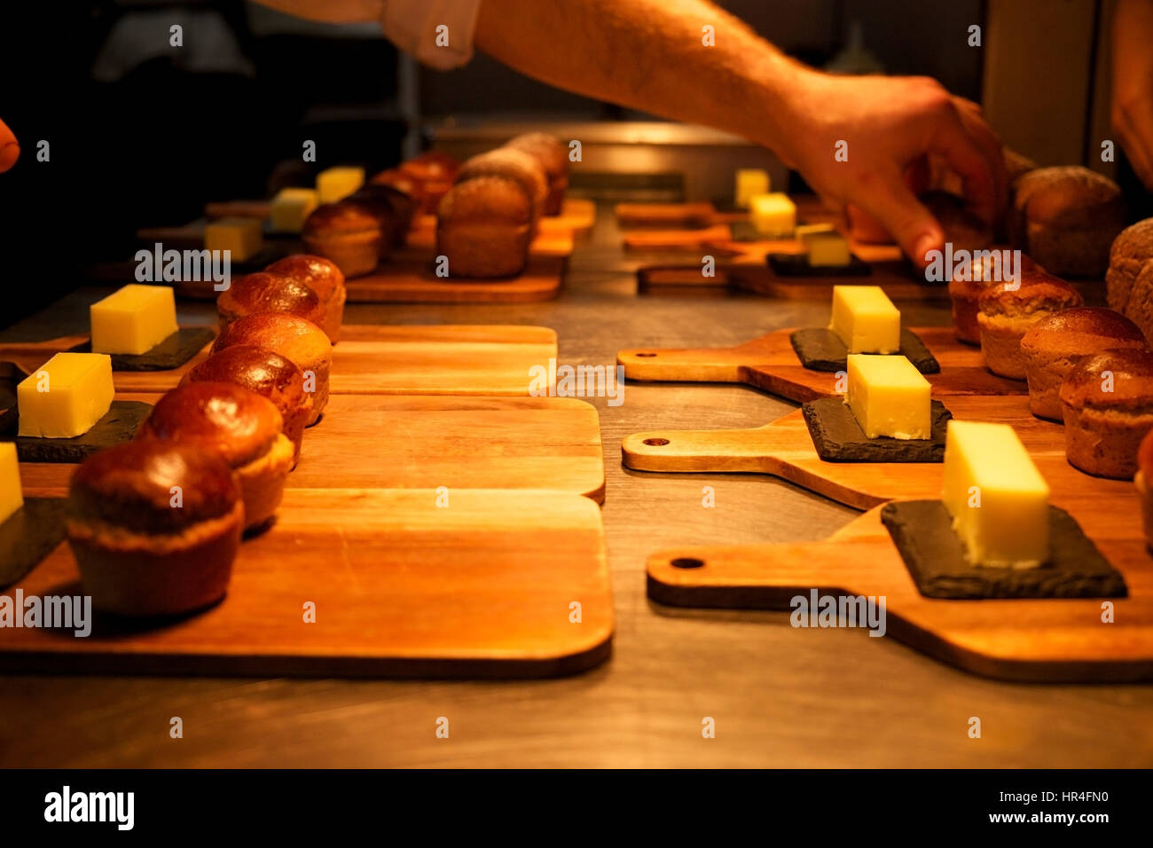 Petits rouleaux de pain fait maison et des carrés de beurre sur des planches organisé sur argent haut cuisine prêt à être servi dans un restaurant, les chefs ha Banque D'Images