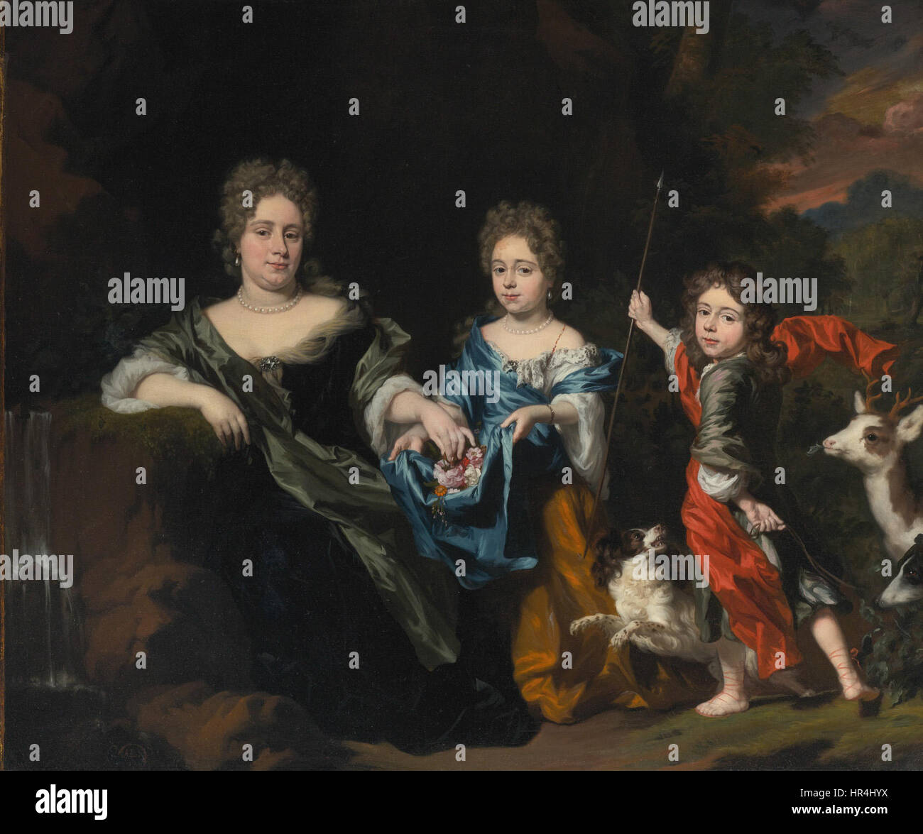 Le portrait de Nicolaes Maes représente une mère et ses deux enfants dans un parc. La peinture met en évidence les liens familiaux et dépeint les sujets dans un environnement extérieur, capturant la lumière naturelle et les détails. L'œuvre reflète l'intérêt du XVIIe siècle pour la vie domestique et la représentation des relations familiales. Banque D'Images