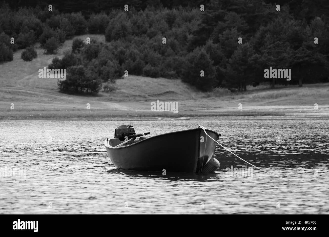 Haute montagne lac bulgare avec bateau de pêche en premier plan, noir et blanc fond bateau Banque D'Images
