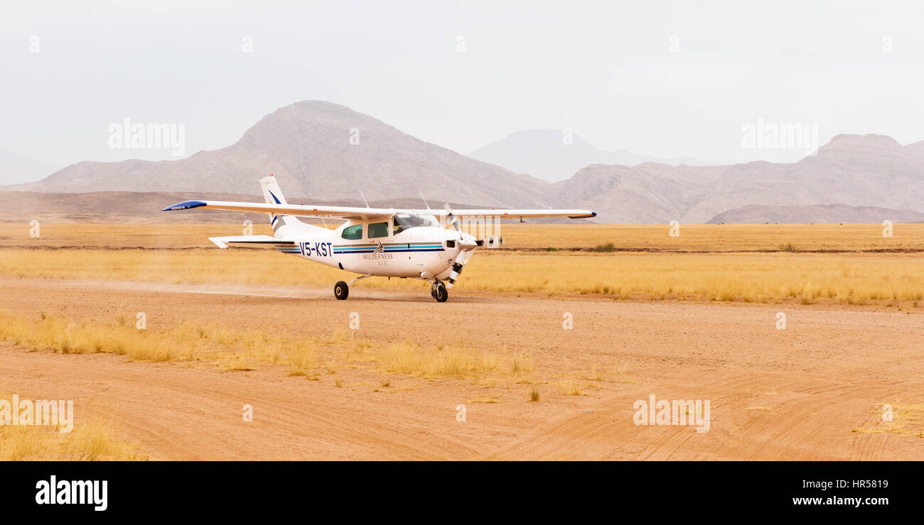 Un Cessna 210, à l'atterrissage à l'aérodrome dans la vallée de Hartmann, Kaokoland, au nord ouest de la Namibie, au service de la Serra Cafema Camp de pleine nature. Banque D'Images