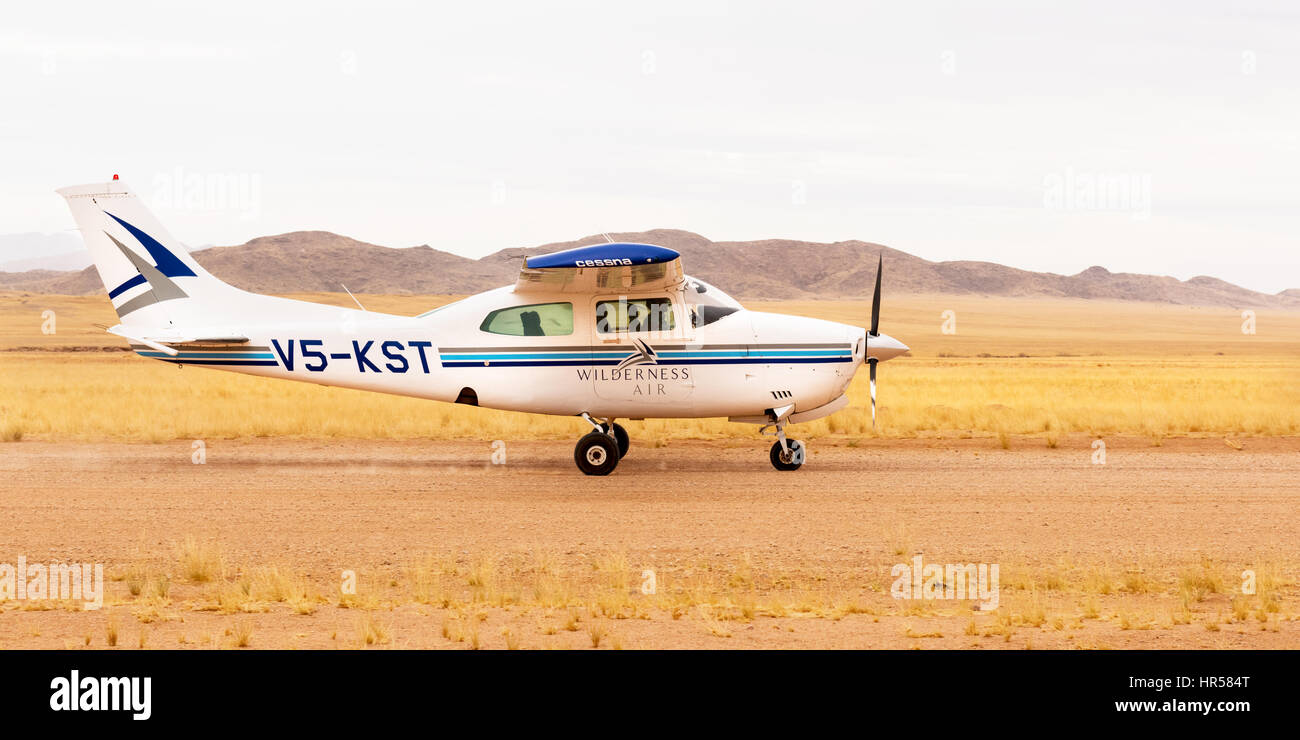 Un Cessna 210, à l'atterrissage à l'aérodrome dans la vallée de Hartmann, Kaokoland, au nord ouest de la Namibie, au service de la Serra Cafema Camp de pleine nature. Banque D'Images