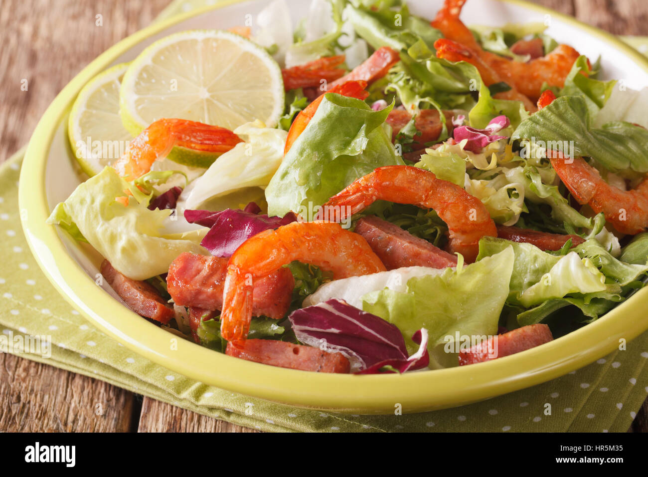 Salade de crevettes, chorizo, chaux, mélanger la laitue sur une assiette horizontale. Banque D'Images