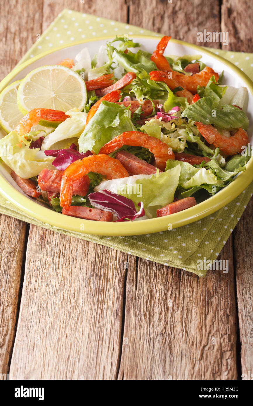 Salade de crevettes, délicieux saucisson chorizo et mélanger la laitue sur une assiette sur la table verticale. Banque D'Images