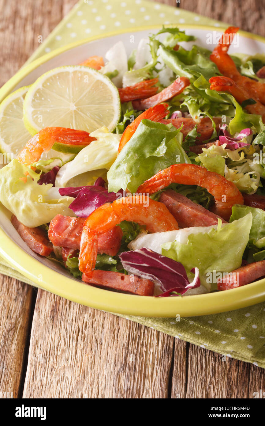 Salade avec crevettes, chorizo et mélanger la laitue sur une assiette sur la table verticale. Banque D'Images