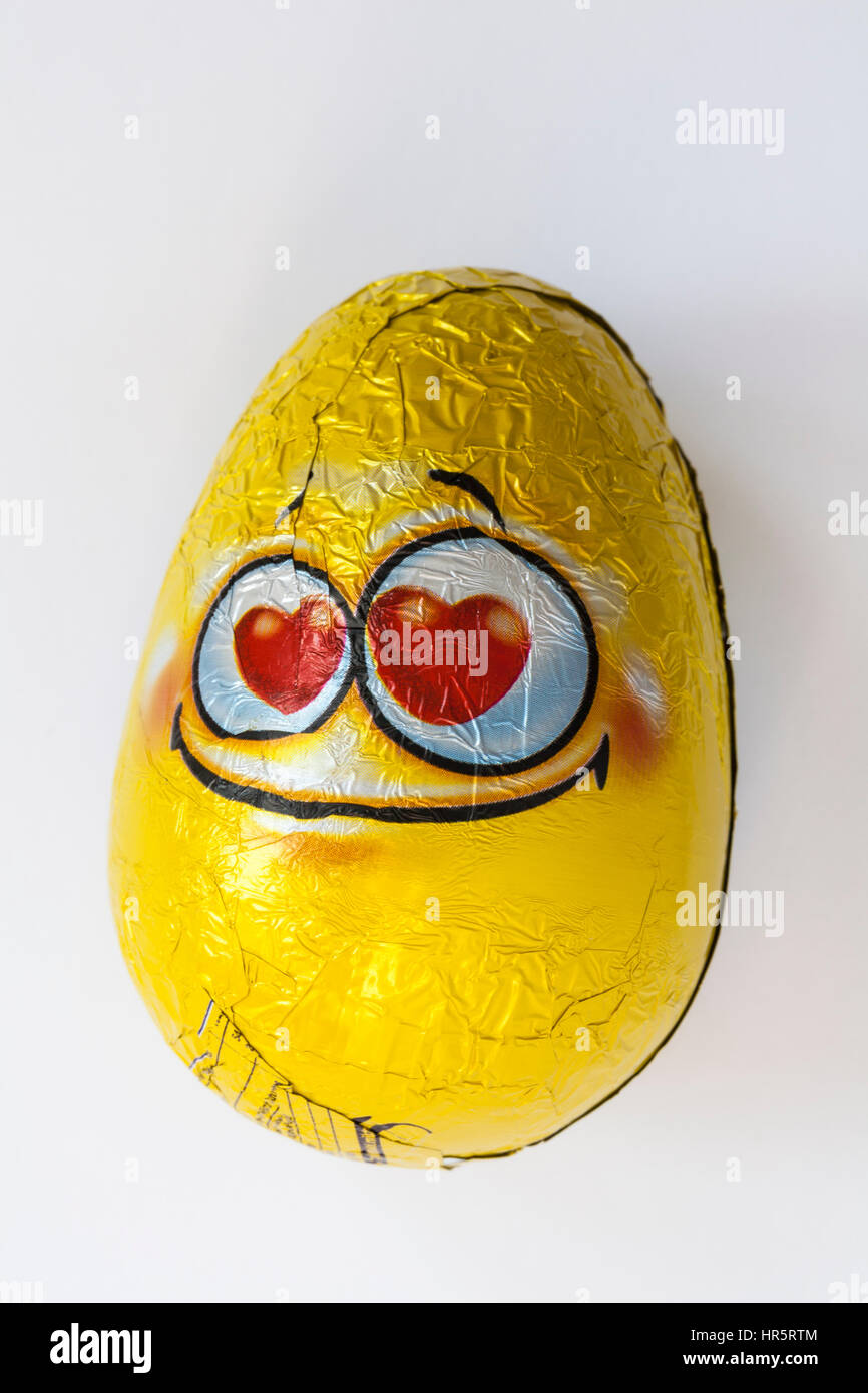 Oeuf chocolat au lait Emoji Toto avec surprise prêt de jouets pour Pâques isolé sur fond blanc Banque D'Images