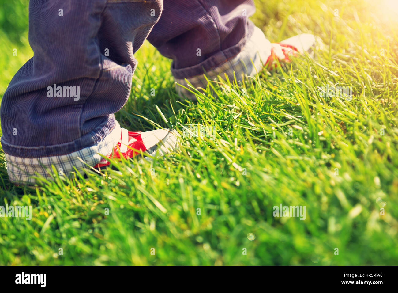 Petit enfant marcher dans un beau jour de printemps. Bébé garçon pieds en  chaussures rouges à l'extérieur dans le jardin Photo Stock - Alamy