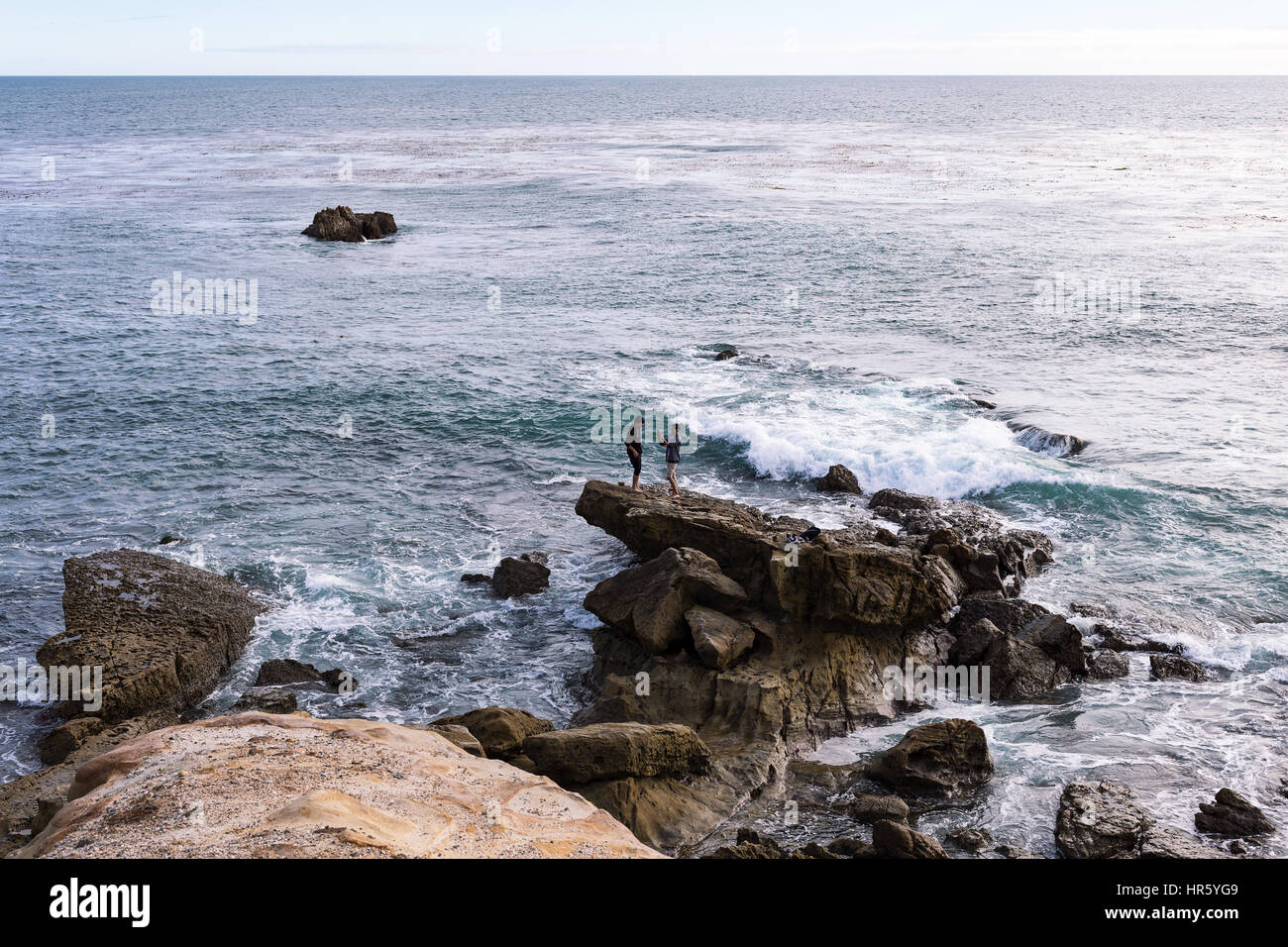 Deux jeunes hommes prenant des photos de téléphone portable au bord de l'océan à Laguna Beach, Californie Banque D'Images