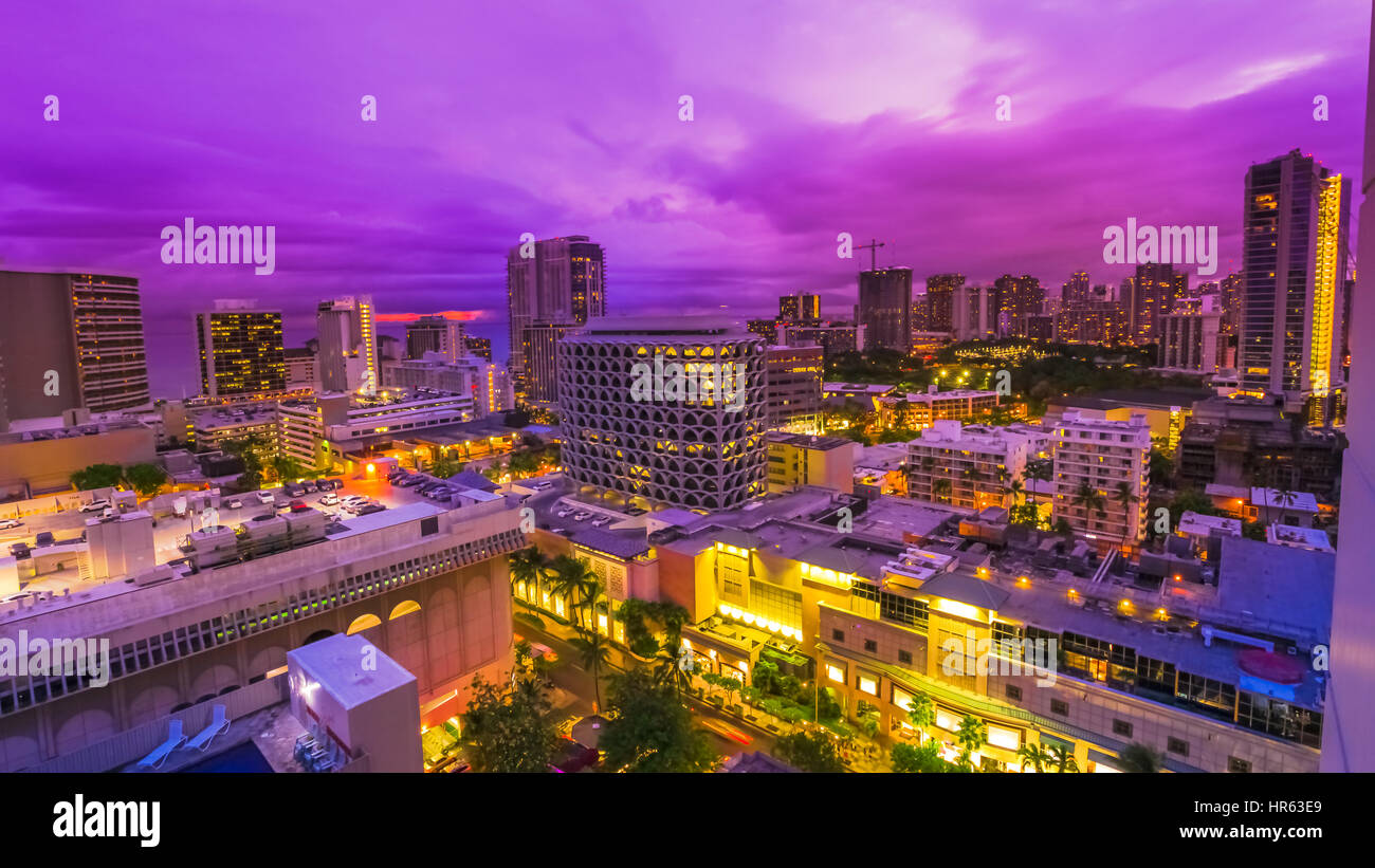 Crépuscule violet des rues de la région de Waikiki, dans l'île d'Oahu, Hawaii, United States. La vie nocturne de la ville de veilleuses et de concept. Banque D'Images