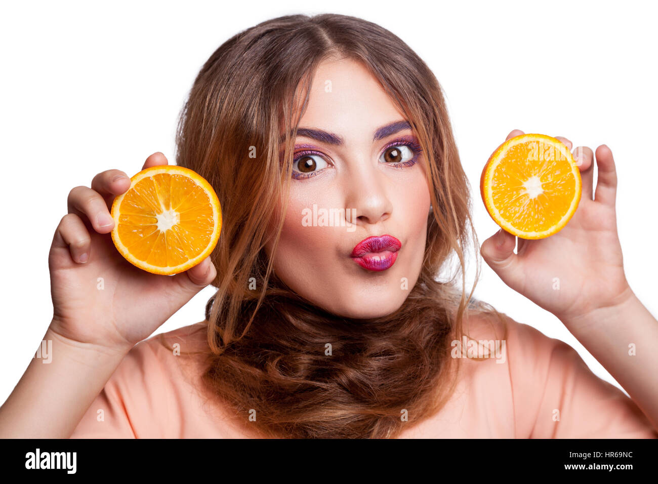 Belle jeune fille drôle avec tranche d'orange et le maquillage et la coiffure looking at camera. studio shot, isolé sur fond blanc. Banque D'Images