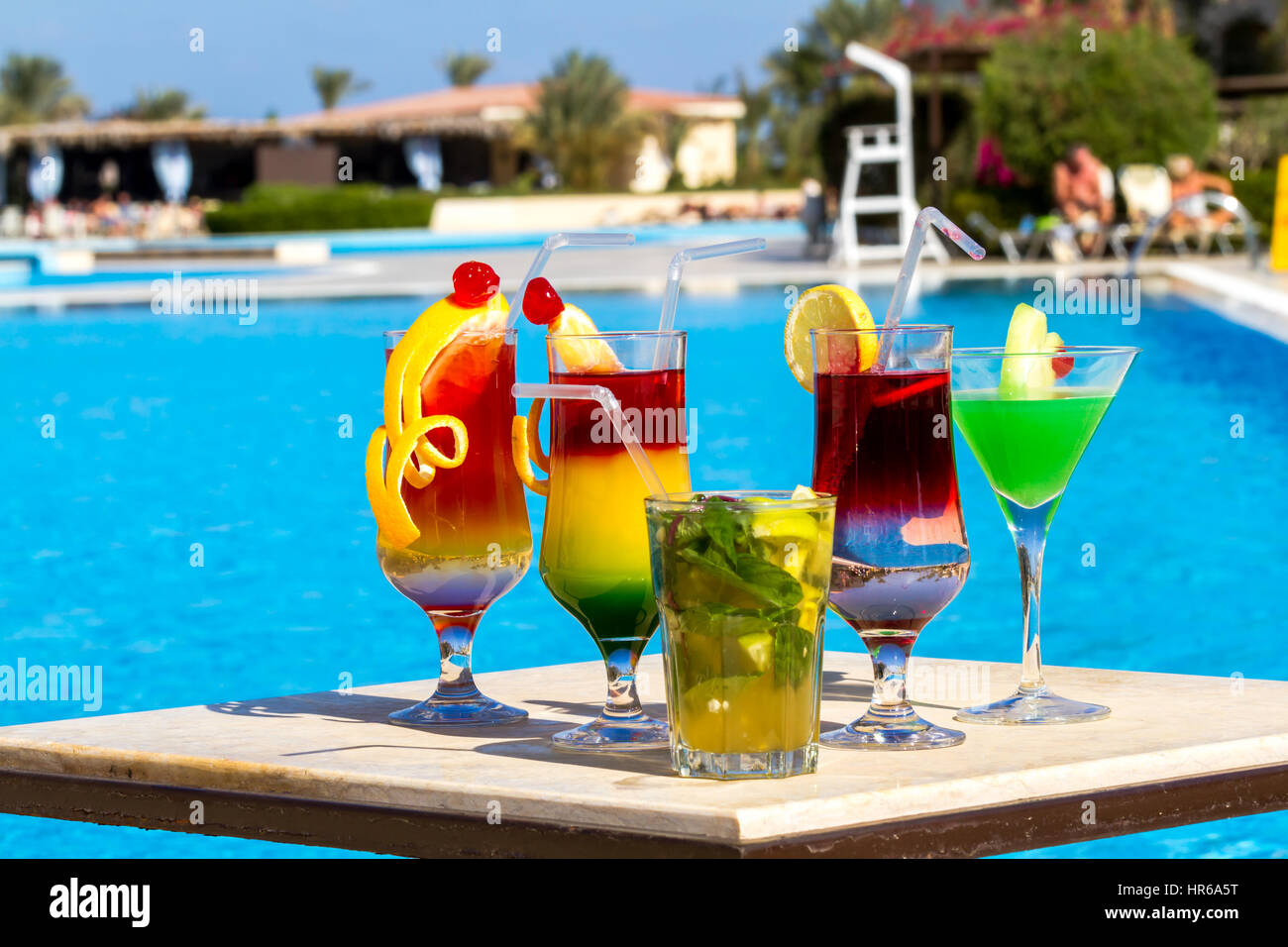 Belle multi-couleur des cocktails sur fond piscine, des filles et des palmiers Banque D'Images