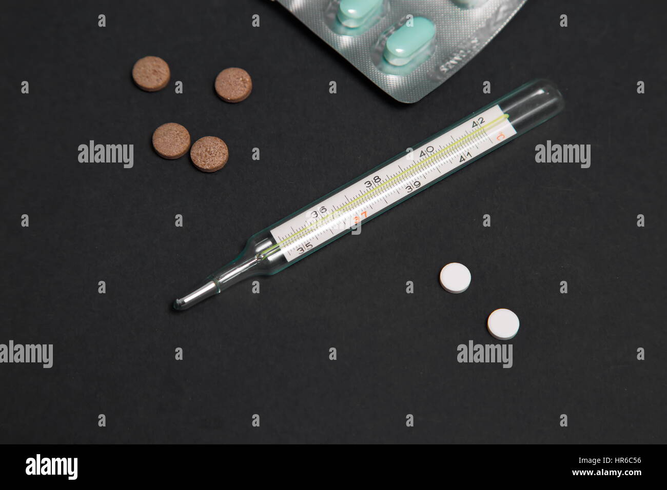 Paquet de pilules bleues avec injection de vert dans l'arrière-plan. Outils médicaux. Banque D'Images