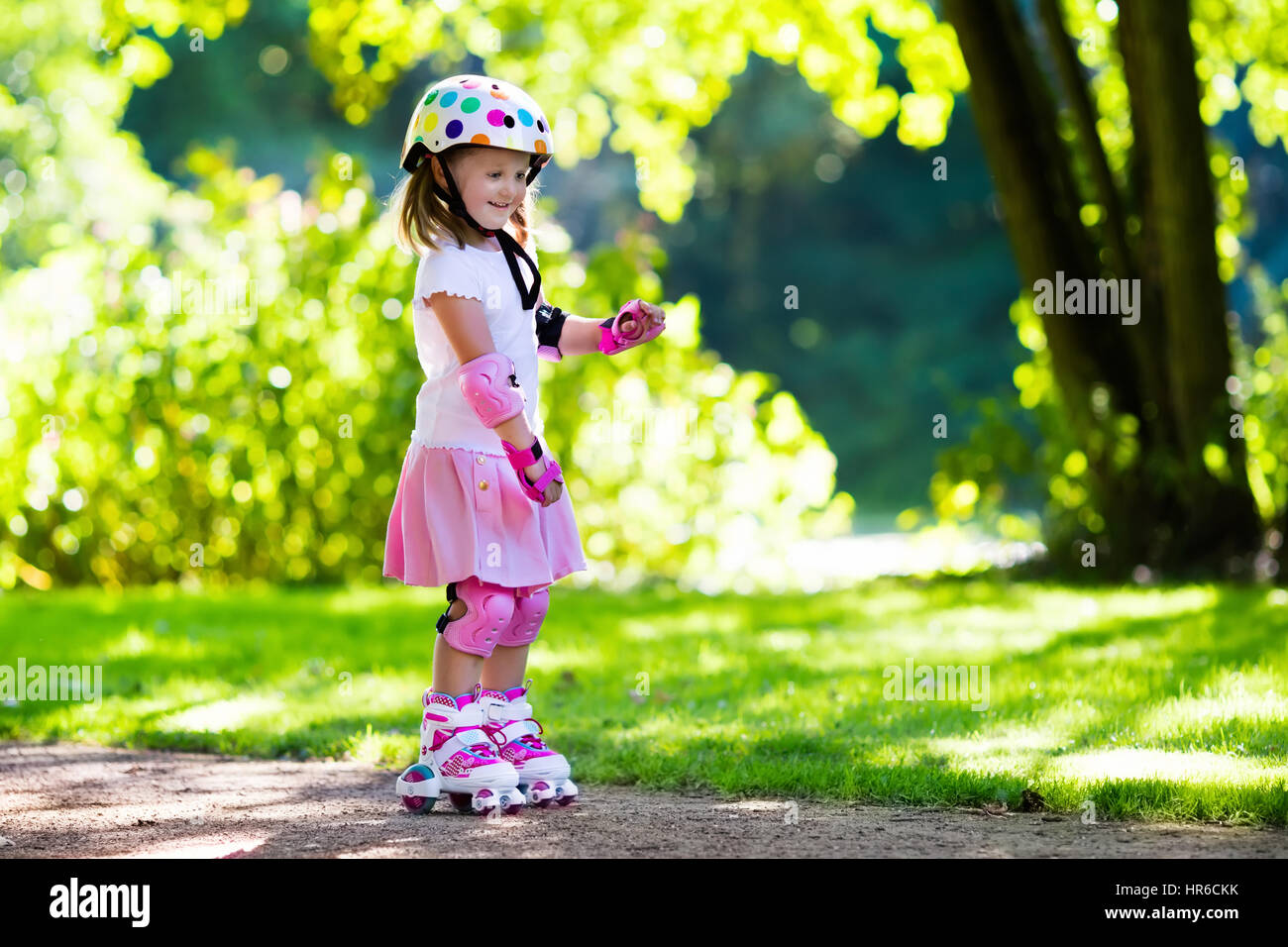 Petite Fille Apprendre À Roller Dans Le Parc Ensoleillé D'été. Un