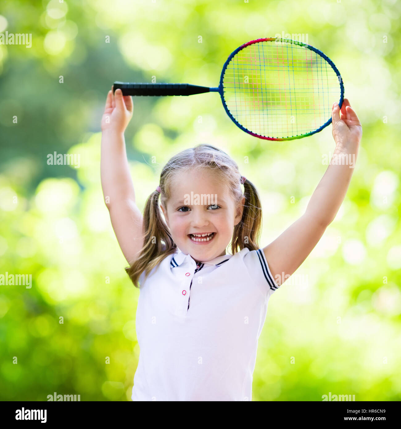 Preschool girl actif à jouer au badminton dans la cour en plein air en été.  Les enfants jouent au tennis. Sport à l'école pour les enfants. Raquette et  volant sport pour ch