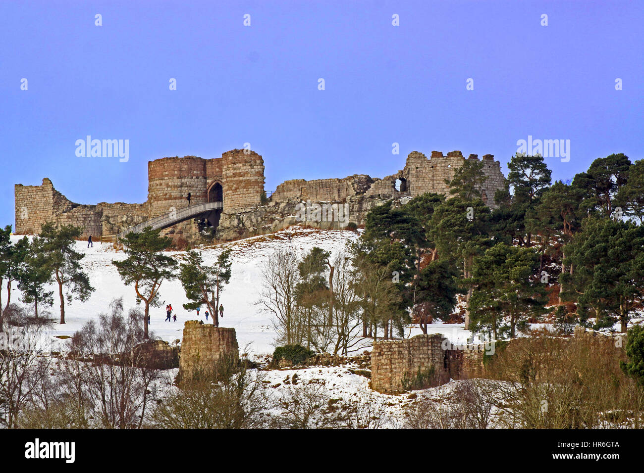 Château de Beeston du 13th siècle Cheshire, sur le sentier de grès, vu en hiver avec un ciel bleu et des visiteurs marchant et jouant dans la neige Banque D'Images