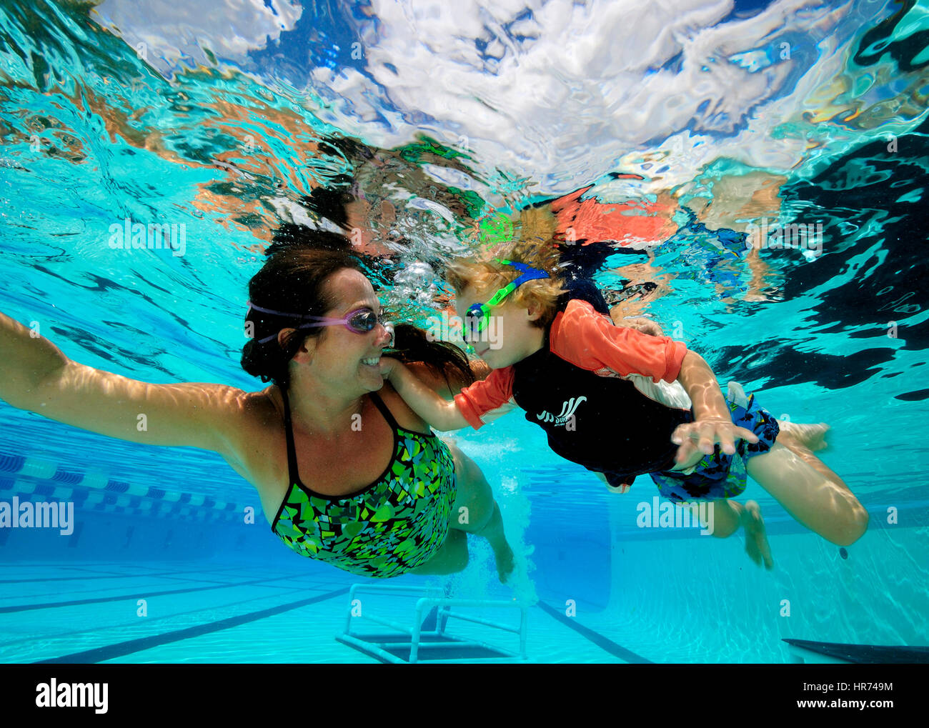 Les enfants nager sous l'eau en profitant de la piscine d'été de détente Banque D'Images