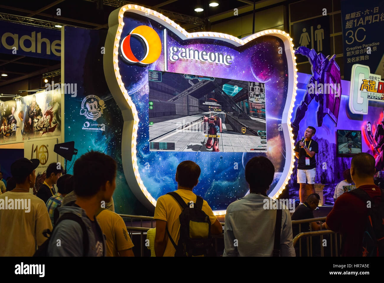 Grand écran de jeu vidéo montrant une concurrence avec les spectateurs à regarder vivre à Hong Kong Banque D'Images