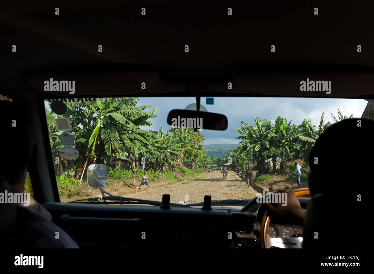 Un pilote navigue dans un village dans le Parc National des Virunga, en République démocratique du Congo, où l'agriculture de subsistance comprend la plantation de banane. Banque D'Images