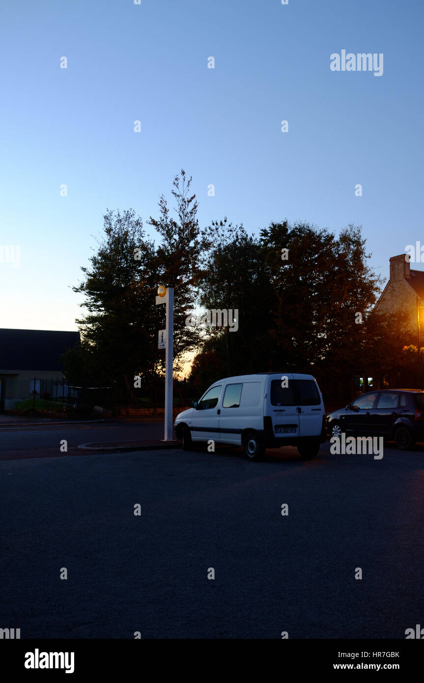 Voiture blanche dans un parking pendant la campagne blue heures de coucher du soleil en Normandie, France Banque D'Images