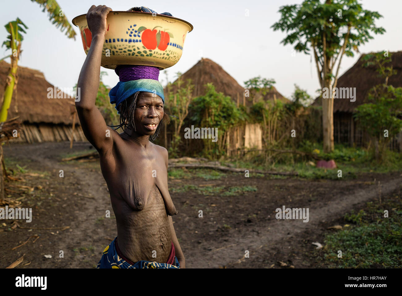 Portrait d'une femme de la tribu de Holi transportant une charge de vêtements sur sa tête. Elle porte la charge à l'eau voisin pour laver les vêtements. Dans Banque D'Images