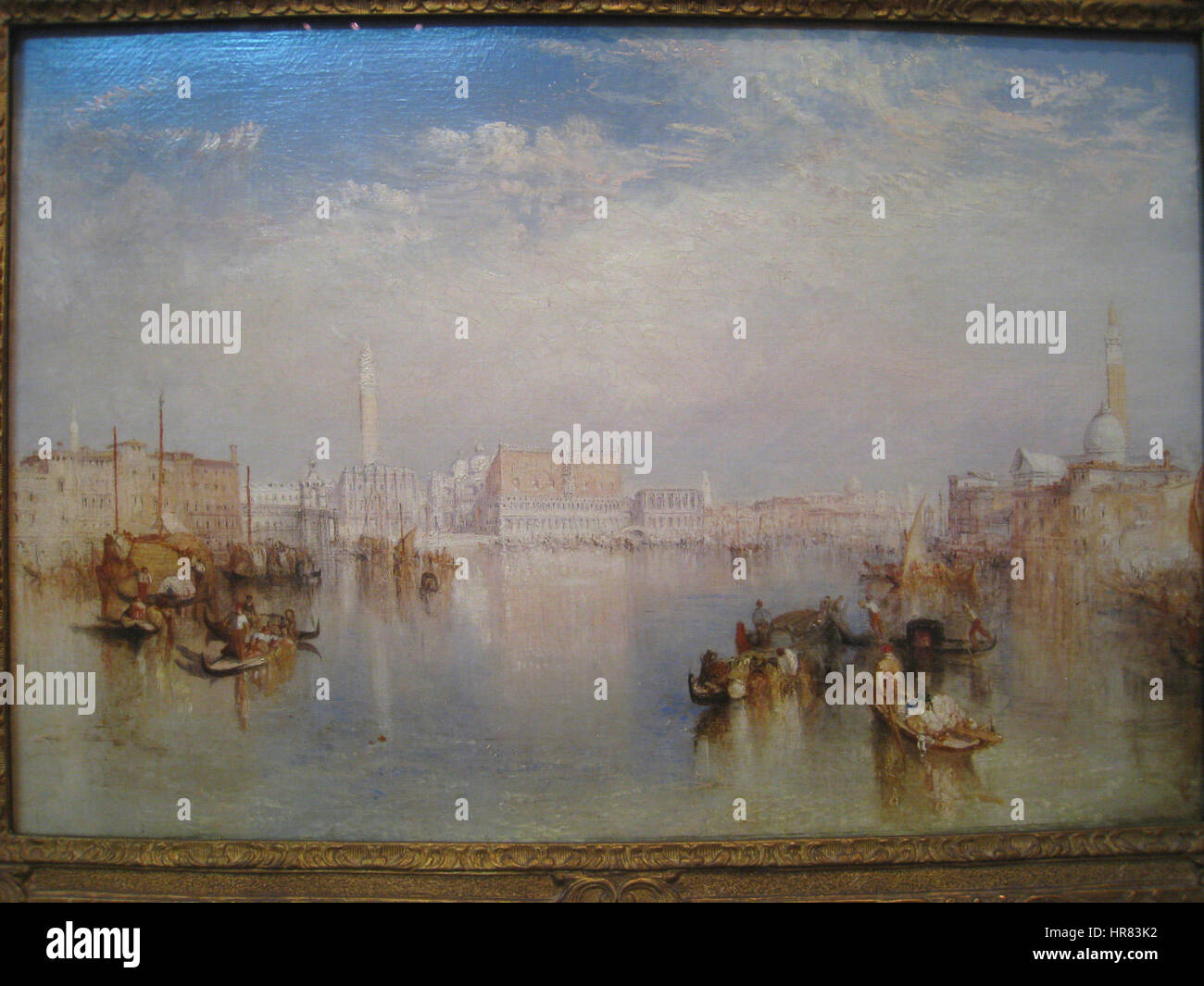 La vue de Venise de J. M. W. Turner capture l'emblématique skyline de Venise, avec le Palais Ducal, le Dogana et l'île de San Giorgio. La technique atmosphérique de Turner et l’utilisation de la lumière créent une représentation dramatique des monuments de la ville. Banque D'Images