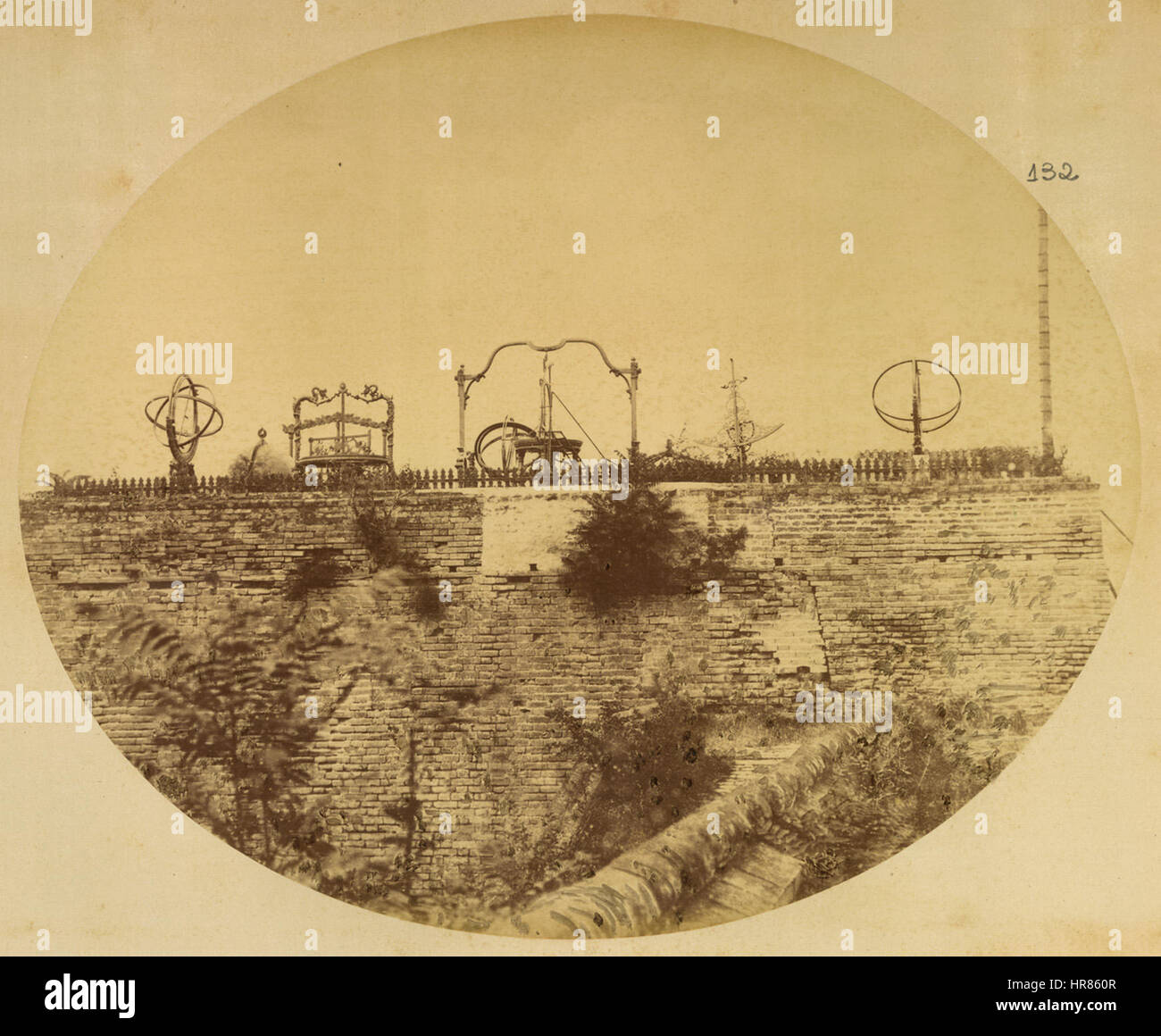 Cette image de 1874 de l'Observatoire de Pékin présente plusieurs instruments astronomiques, dont une sphère armillaire utilisée pour la navigation céleste. L'observatoire était un site clé pour la recherche astronomique dans la Chine de la dynastie Qing. L'image met en évidence le rôle de l'observation scientifique dans l'histoire chinoise, marquant une période significative de progrès astronomique. Banque D'Images