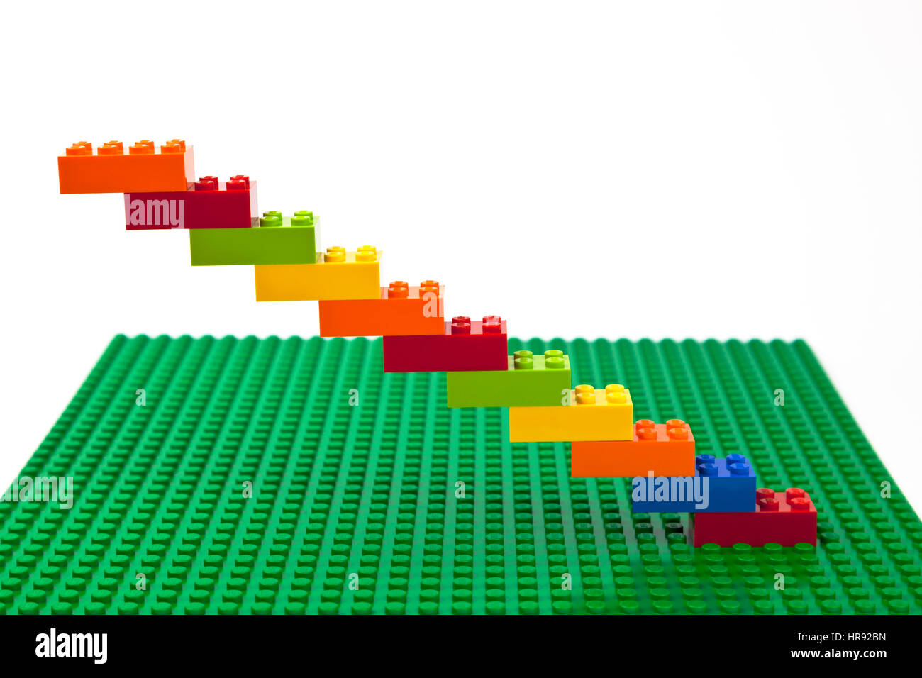 Construction brique Lego colorés d'escalier ou un dessin sur une plaque de base Lego vert. Banque D'Images