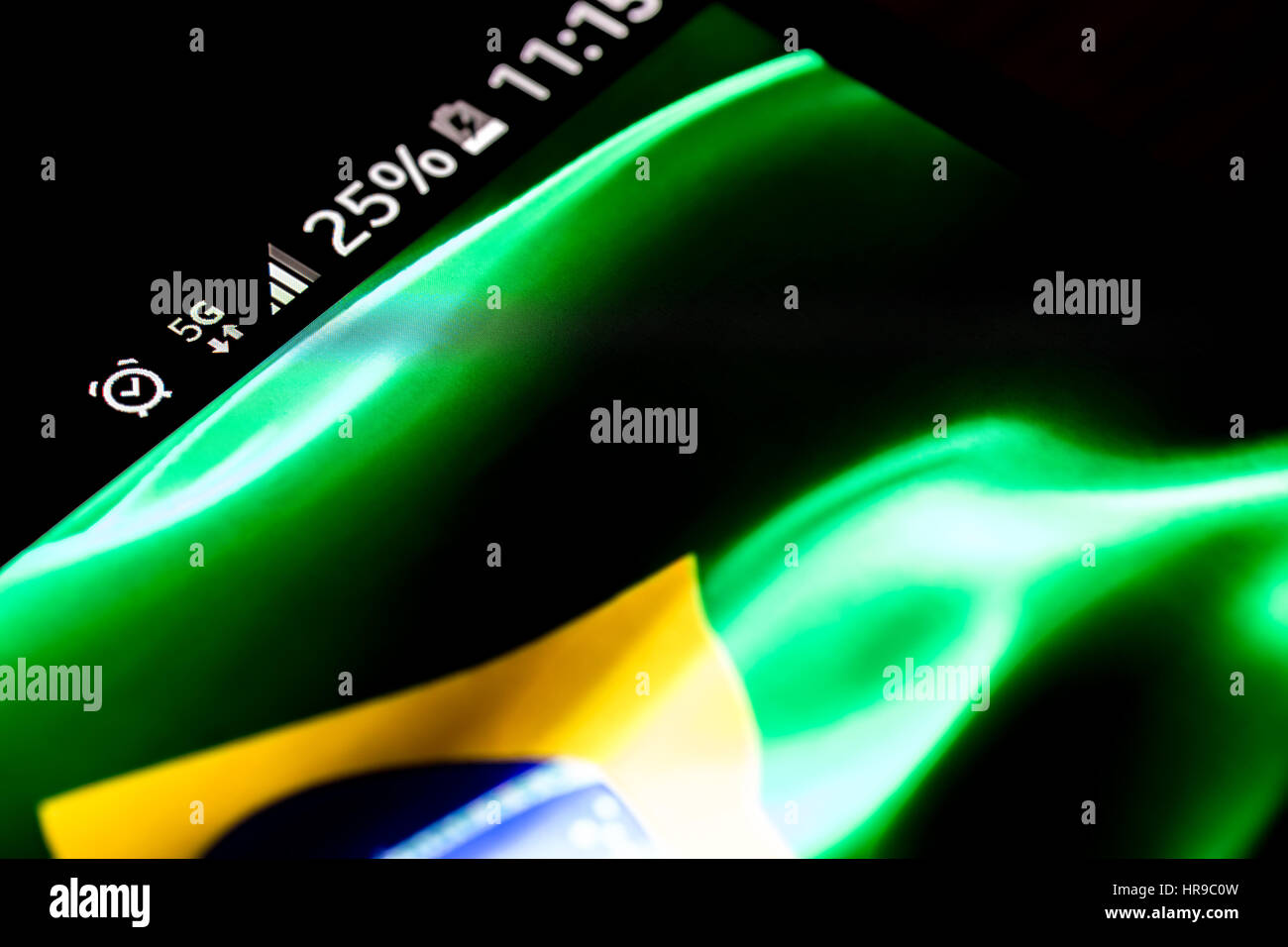 Sur fond de bois avec smartphone 5G Réseau inscription 25  % et le Brésil drapeau sur l'écran. Banque D'Images